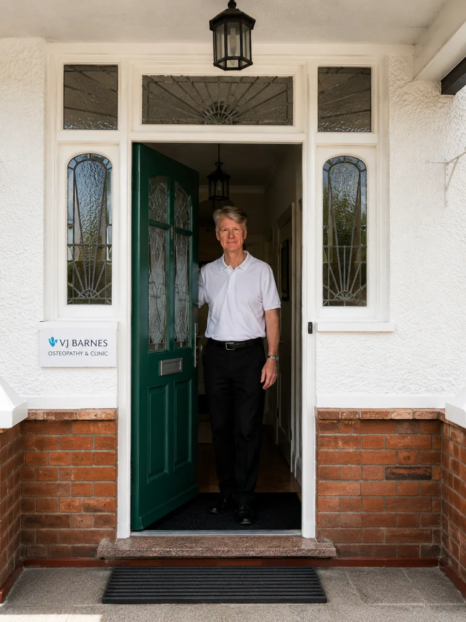 Vincent Barnes at the clinic's green front door, beside the VJ Barnes Osteopathy & Clinic sign